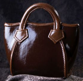 Handtasche Rigit aus Zartbitterschokolade mit zwei Henkeln und dekorativen Riemen