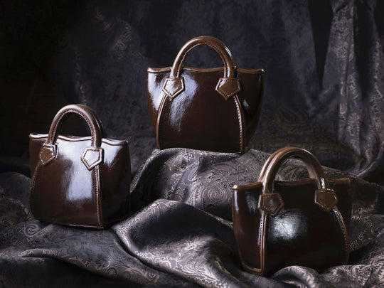Handtasche Rigit aus Zartbitterschokolade mit zwei Henkeln und dekorativen Riemen